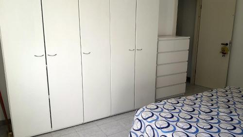 1 dormitorio con armarios blancos y 1 cama en Casa Perego, en Monza