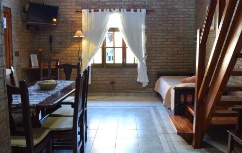 a dining room with a table and a window at Cabañas La Aldea in Villa Carlos Paz