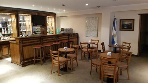 un restaurante con mesas y sillas y un bar en Hotel Kapenke en El Calafate