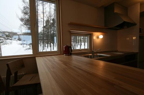 uma cozinha com um balcão de madeira e uma janela em Forest View em Furano
