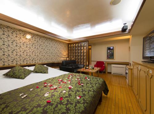 una habitación de hotel con una cama con flores. en Restay Yashio (Adult Only), en Yashio