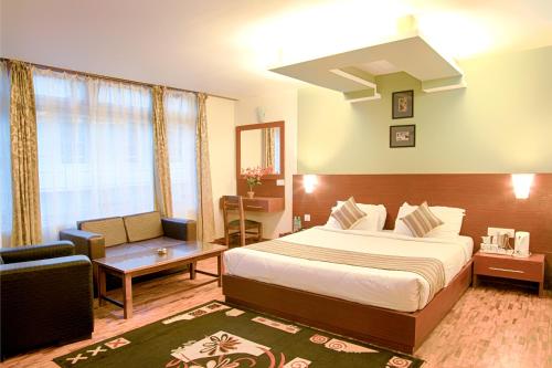 Habitación de hotel con cama y sofá en Hotel Le Primula, en Gangtok