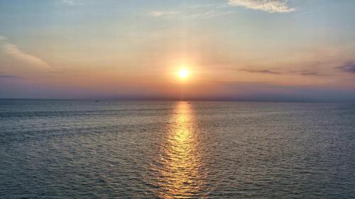 a sunset over the ocean with the sun in the sky at XYZ Private Spa and Seaside Resort in Shirahama