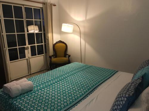 a bedroom with a bed and a window and a chair at Magic Garden House in Cali