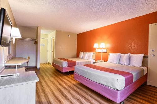 a hotel room with two beds and a flat screen tv at Cathedral Hill Hotel in San Francisco
