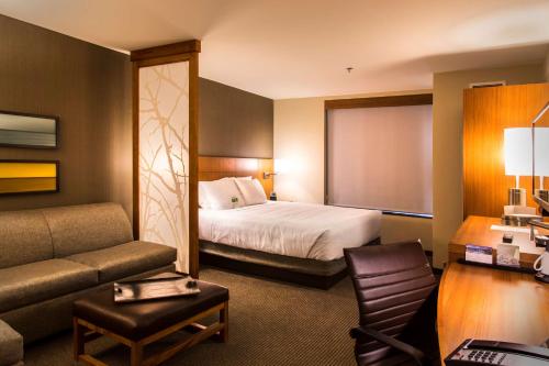 a hotel room with a bed and a couch at Hyatt Place Charlottesville in Charlottesville