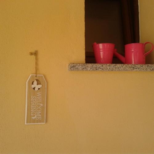 シニスコーラにあるPiccolo accogliente monolocaleの壁に看板を貼った棚の赤い杯