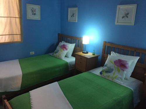 two beds in a room with two green sheets at Stephen Center B&B in Tirana