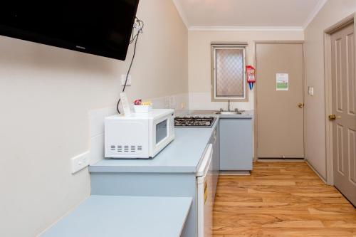 a kitchen with a microwave and a counter top at Discovery Parks - Port Hedland in Port Hedland