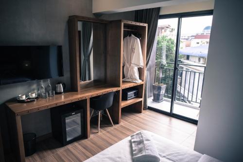 a room with a desk with a television and a balcony at Lavanya Boutique Hotel in Phnom Penh