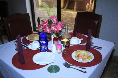 a table with two plates of food and flowers on it at Sangana Lodge in Moshi