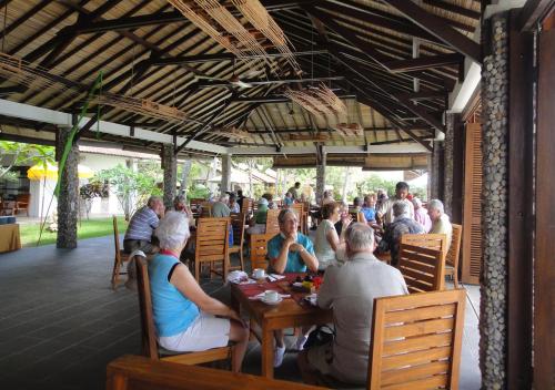 a group of people sitting at a table in a restaurant at Cocotinos Sekotong Lombok in Sekotong