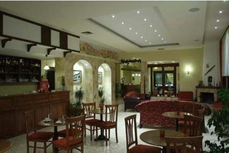 a restaurant with tables and chairs and a bar at Hotel Siatista in Siatista