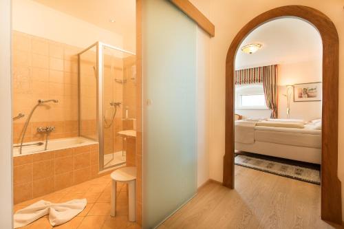 a bathroom with a shower and a bath tub at Hotel Schloss Lerchenhof in Hermagor