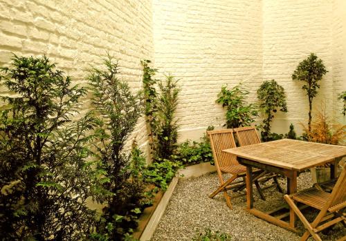 a wooden table and two chairs in a garden at De Mot B&B in Brussels