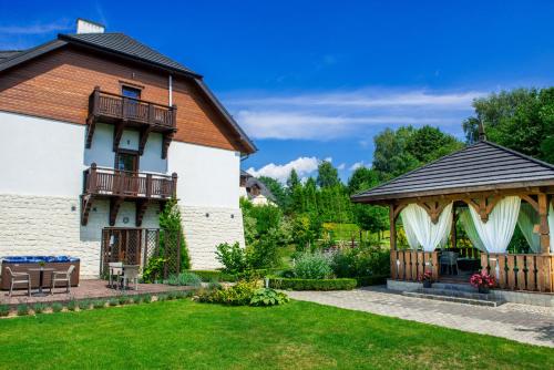 a garden with a gazebo and a house at Hotel Kazimierzówka in Kazimierz Dolny