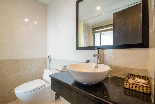 a bathroom with a sink and a toilet and a mirror at Dana Marina Boutique Hotel in Da Nang