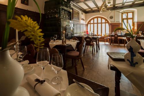 エルトフィレ・アム・ラインにあるHotel und Weinhaus Zum Krugのワイングラス付きのテーブルと椅子のあるレストラン