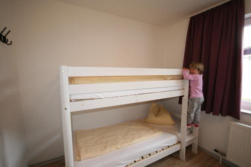 a little girl standing on top of a bunk bed at Appartements Domizil in Kaprun