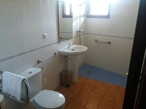 a bathroom with a toilet and a sink at Hospedería Prepirineo in Undués-Pintano