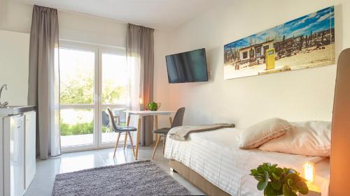 een slaapkamer met een bed, een tafel en een raam bij City Hotel ApartW3 - kostenlos parken in Bad Oeynhausen