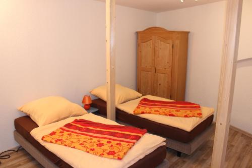 2 camas en una habitación con espejo en Pension Holly, en Oschatz