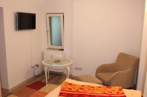 ein kleines Zimmer mit einem Stuhl und einem Tisch in der Unterkunft Pension Holly in Oschatz