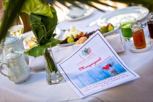 een tafel met een bord eten en een bord erop bij Seehotel Sparer in Appiano sulla Strada del Vino