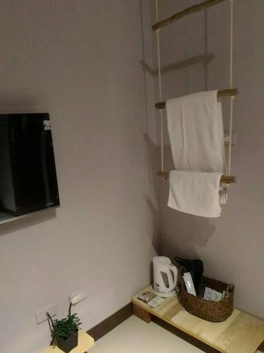 a bathroom with a towel rack and a tv and towels at Woods Decor - Anping in Tainan