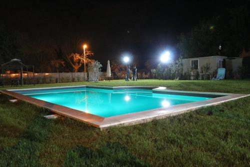 a swimming pool in a yard at night at Parcoverdepino in Bastia Umbra