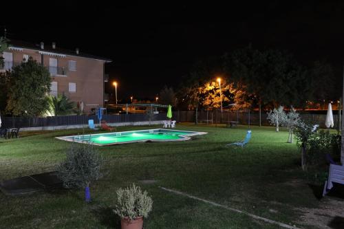 a yard with a swimming pool at night at Parcoverdepino in Bastia Umbra