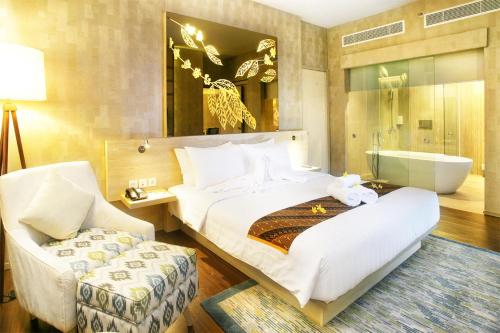 1 dormitorio con 1 cama grande y bañera en Hotel Grand Zuri Muara Enim, en Muaraenim