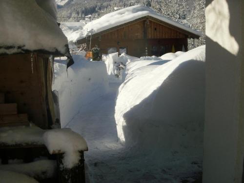 a yard covered in snow next to a building at Badhaus in Achenkirch