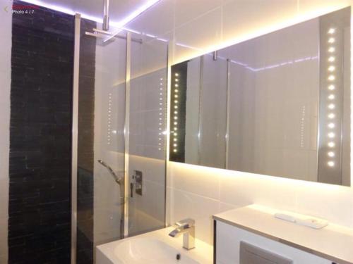 une salle de bain avec un lavabo et un miroir dans l'établissement Au calme du bois du Pouliguen plage et port à pied, au Pouliguen