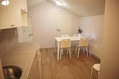 a kitchen with a white table and chairs at Savonlinnan Kansanopisto - Wanha Pappila in Savonlinna