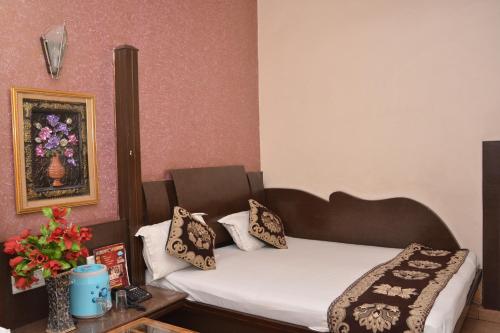 a small room with a bed with pillows on it at Hotel Yatri International in New Delhi