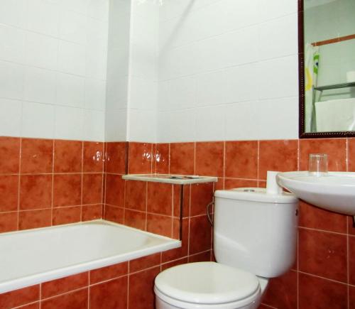 y baño con aseo, lavabo y bañera. en Hostal Villa en Chiclana de la Frontera