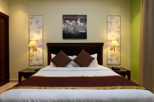 a bedroom with a large bed with two night stands at Jazan Inn Hotel in Jazan