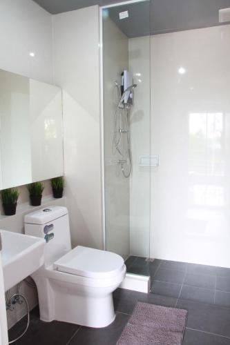 a bathroom with a shower and a toilet and a sink at Bangkok Boutique Resort Rangsit in Pathum Thani