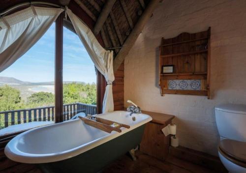 eine Badewanne im Bad mit Fenster in der Unterkunft Monkey Valley Resort in Noordhoek