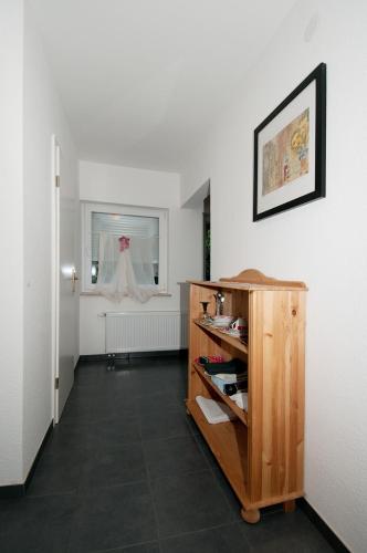 a room with a white wall and a wooden cabinet at Landhotel Alte Mühle in Modautal