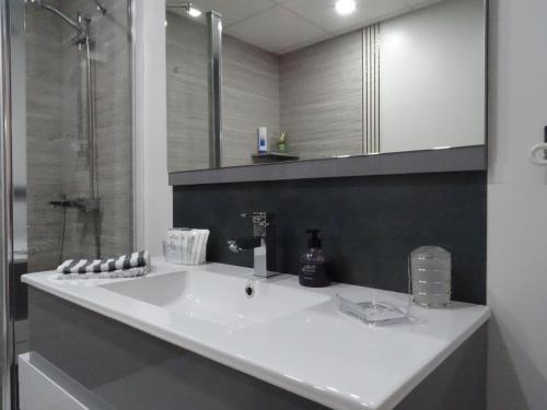 グラナダにあるApartamento Parque Almuniaのバスルーム(白い洗面台、鏡付)
