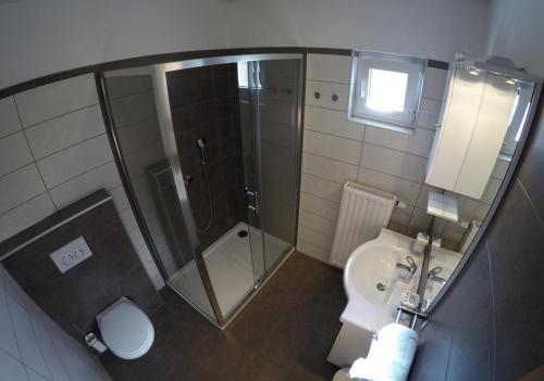 a bathroom with a shower and a toilet and a sink at Apartments and Rooms Rea in Sveti Martin na Muri