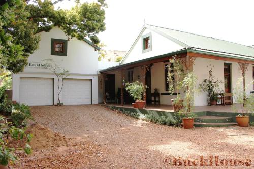 a white house with a driveway in front of it at Buckhouse Elegant Village Apartment in Heidelberg