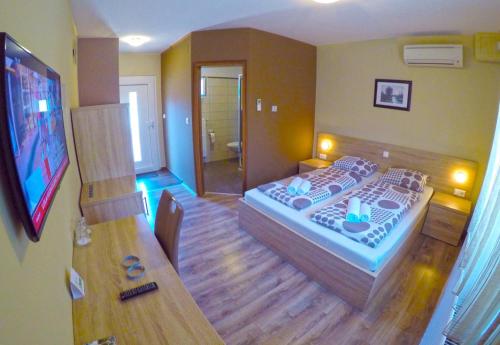 a room with a bedroom with a bed and a television at Apartments and Rooms Rea in Sveti Martin na Muri