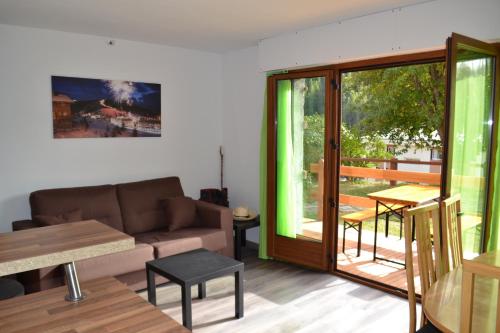 a living room with a couch and a sliding glass door at Edelweiss Valberg in Valberg