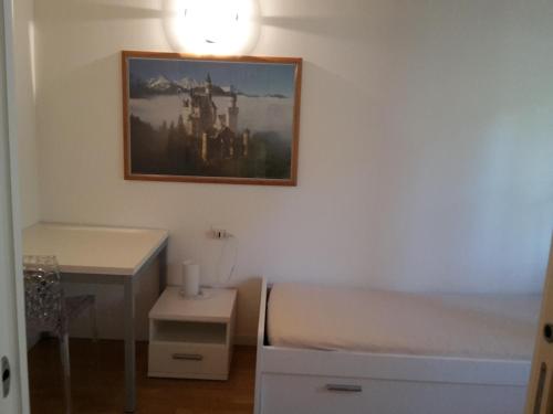 a bedroom with a bed and a desk and a painting on the wall at Villaggio delle Alpi in Pré-Saint-Didier