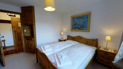 a bedroom with a large bed with white sheets at Sur Ovas 8 in La Punt-Chamues-ch
