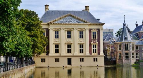a large white building next to a body of water at Pearl of the Hague - R.Q.C. in The Hague