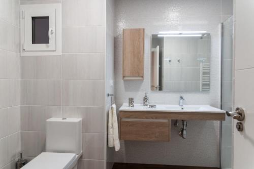 a white bathroom with a sink and a toilet at El Horno de los Bizcochos in Toledo